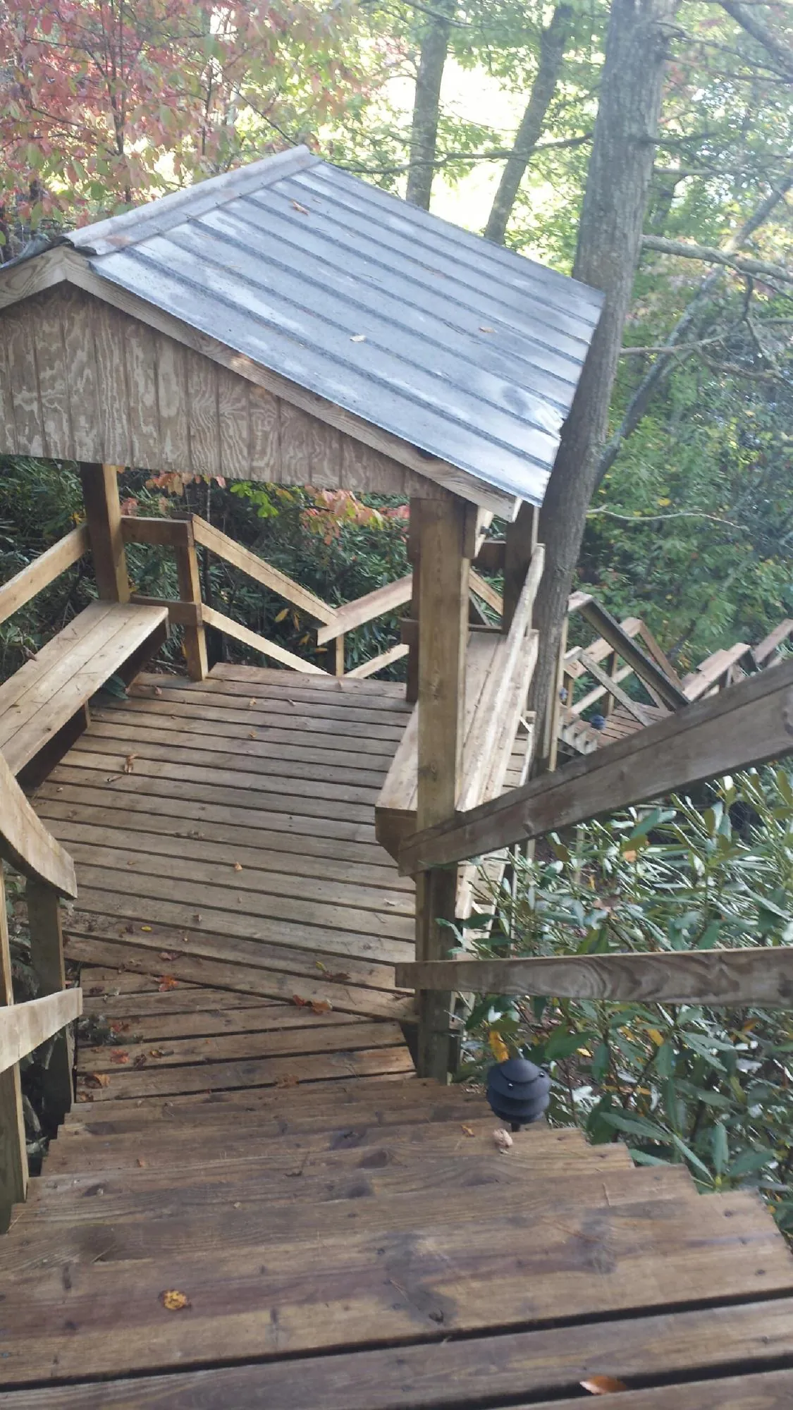 Metal roofed shelter over wooden steps on a wooded walkway — Skylight Repair & Installation work by our crew in Fiskdale