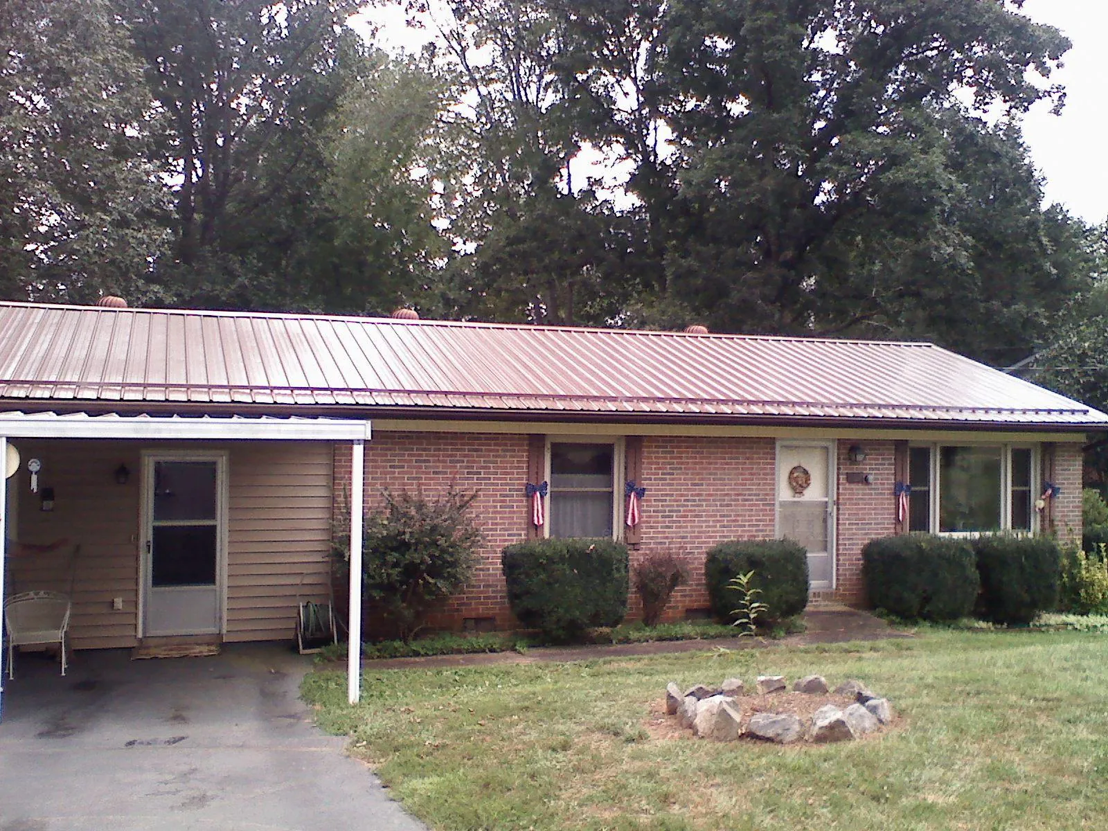 Bronze metal roof and carport on a brick ranch home — Roof Repair work by our crew in Fiskdale